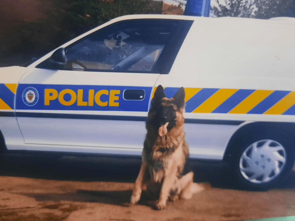PD Ash sits beside a police van